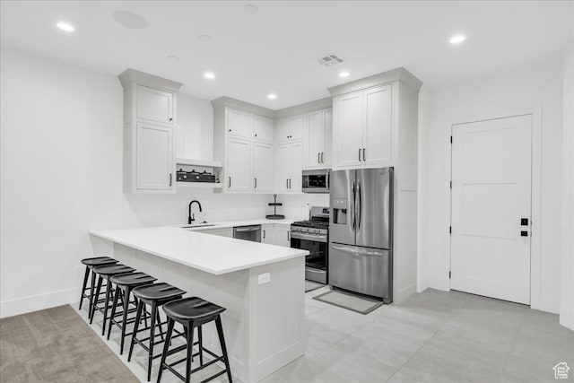4009 S 2420 E, St George, UT 84790 - kitchen featuring stainless steel appliances, a peninsula, a breakfast bar area, recessed lighting, and light countertops