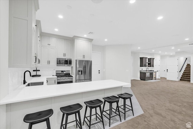 4009 S 2420 E, St George, UT 84790 - kitchen featuring stainless steel appliances, a peninsula, light carpet, recessed lighting, and light countertops