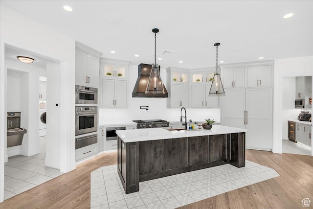 4009 S 2420 E, St George, UT 84790 - kitchen with custom range hood, a warming drawer, light countertops, light wood-style flooring, and washer / clothes dryer