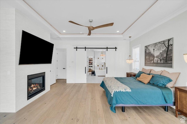 4009 S 2420 E, St George, UT 84790 - bedroom with a barn door, hardwood / wood-style flooring, a tray ceiling, ornamental molding, and recessed lighting