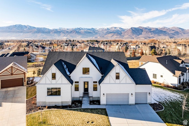 view of front of house featuring a mountain view, a garage, and a front lawn
