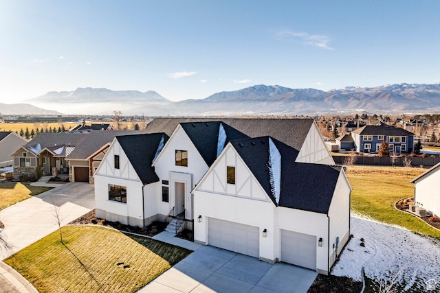 view of front of property featuring a mountain view, a garage, and a front lawn