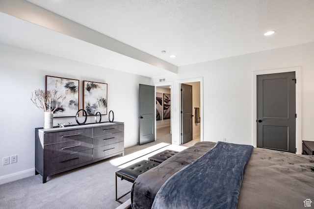 bedroom featuring light colored carpet and a textured ceiling