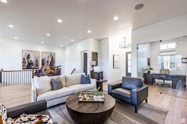 living room featuring an inviting chandelier and light hardwood / wood-style flooring