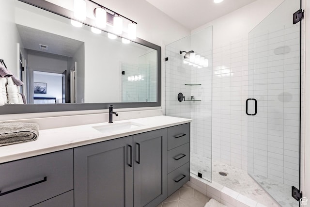 bathroom with tile patterned flooring, vanity, and walk in shower