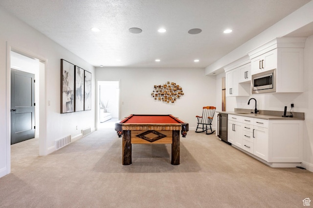 playroom featuring a textured ceiling, sink, light colored carpet, and billiards