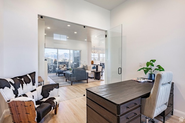office space featuring a notable chandelier and light hardwood / wood-style floors