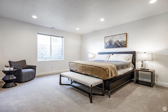 bedroom featuring a textured ceiling and light carpet