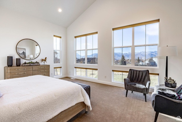 carpeted bedroom with a mountain view, high vaulted ceiling, and multiple windows