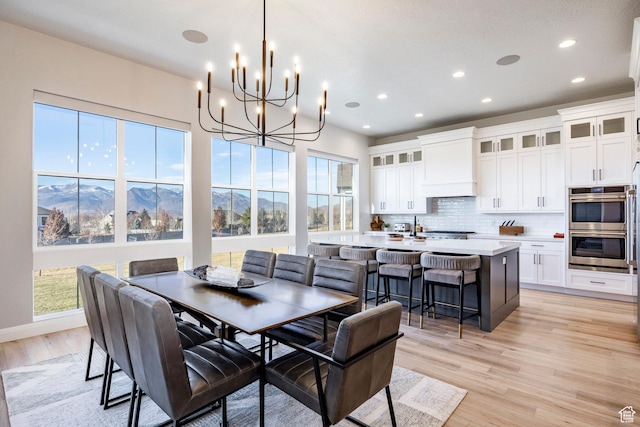 dining space with a mountain view, light hardwood / wood-style flooring, and plenty of natural light