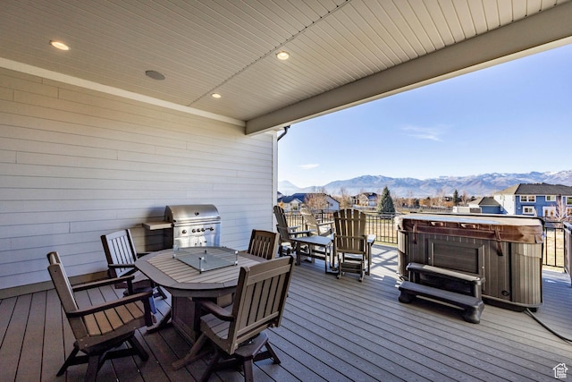 wooden terrace featuring a mountain view, a hot tub, and a grill