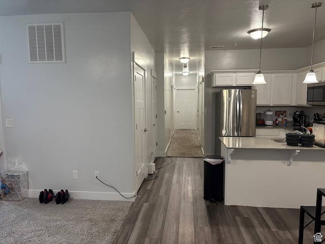 1772 W Terra Vista Ln Unit G101, Saratoga Springs, UT 84045 - kitchen featuring white cabinetry, a breakfast bar, dark wood-type flooring, and appliances with stainless steel finishes