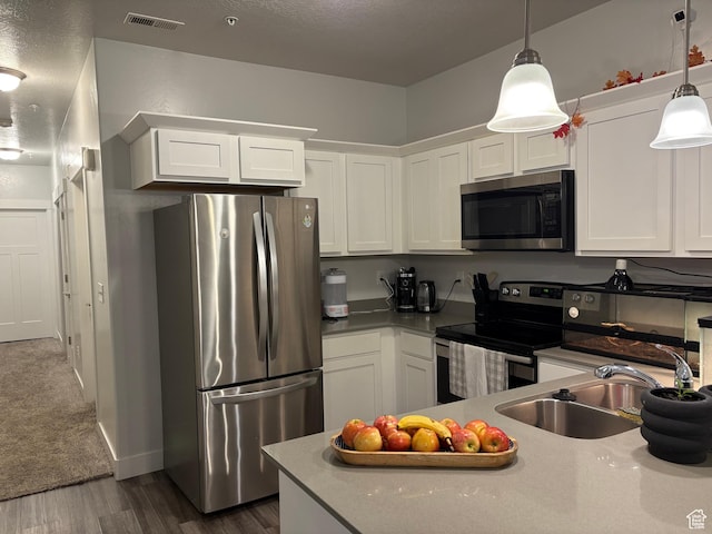 1772 W Terra Vista Ln Unit G101, Saratoga Springs, UT 84045 - kitchen with white cabinets, appliances with stainless steel finishes, dark hardwood / wood-style floors, and hanging light fixtures