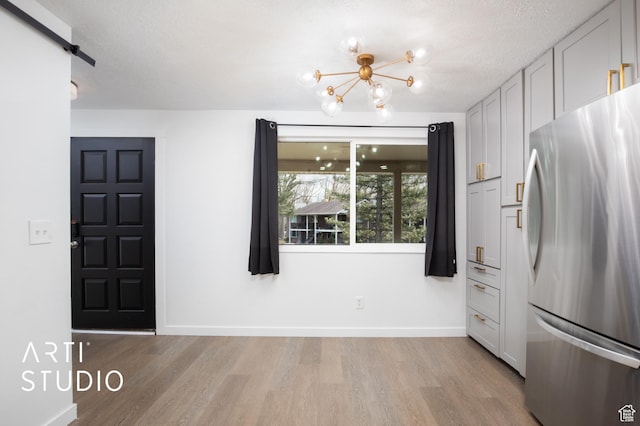 4748 S 700 E Unit 97, Murray, UT 84107 - foyer with light wood-style flooring, a chandelier, baseboards, and a textured ceiling