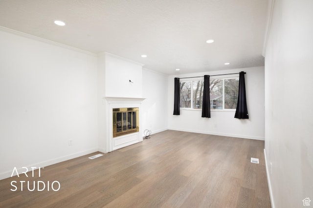 4748 S 700 E Unit 97, Murray, UT 84107 - unfurnished living room featuring wood finished floors, recessed lighting, crown molding, a glass covered fireplace, and baseboards