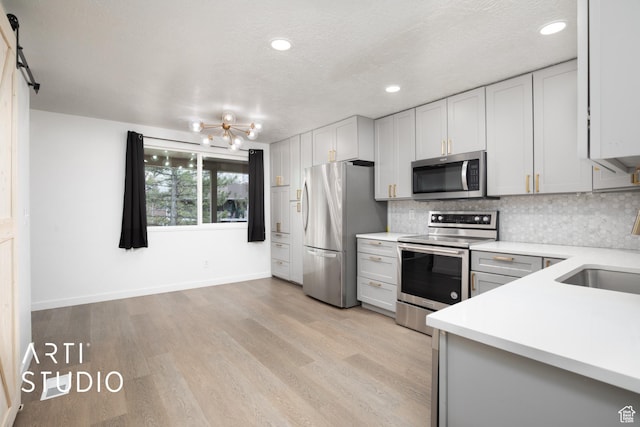 4748 S 700 E Unit 97, Murray, UT 84107 - kitchen with stainless steel appliances, light countertops, tasteful backsplash, recessed lighting, and light wood-type flooring
