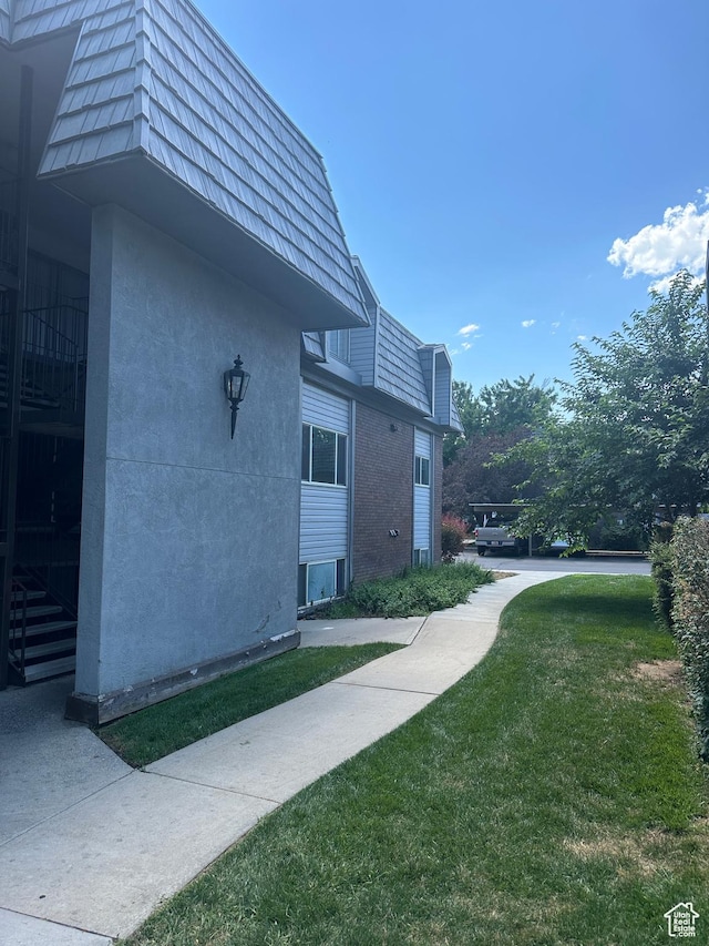1704 N Hickory Ln W, Provo, UT 84604 - view of side of home featuring mansard roof, a lawn, and stucco siding