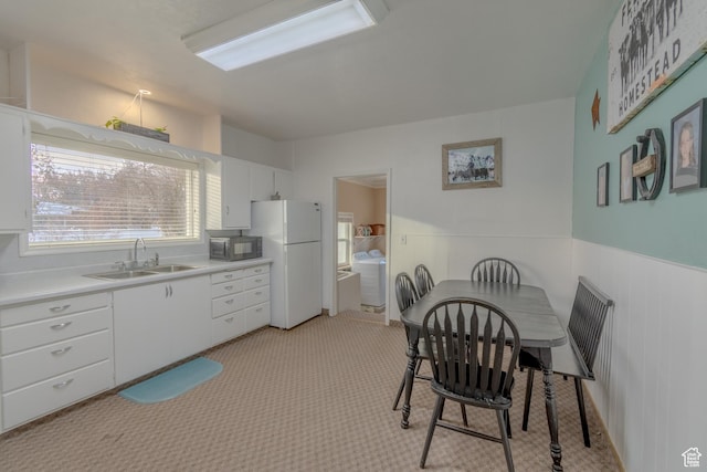 906 S Main St, Grace, ID 83241 - kitchen with freestanding refrigerator, white cabinetry, light countertops, light carpet, and washer and clothes dryer