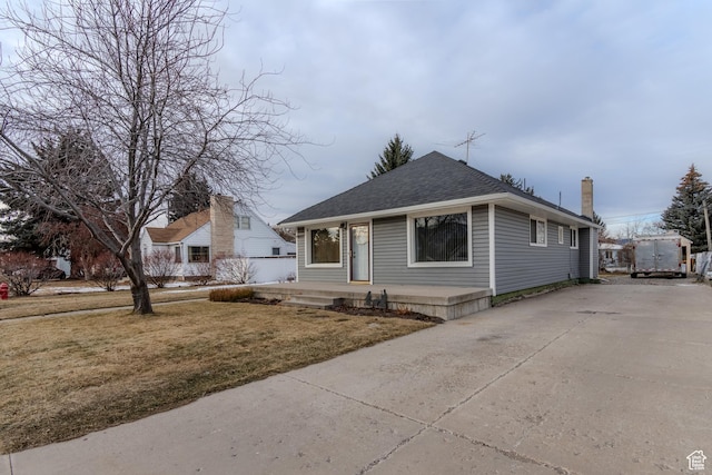 906 S Main St, Grace, ID 83241 - bungalow-style house featuring roof with shingles, covered porch, a front lawn, a chimney, and driveway