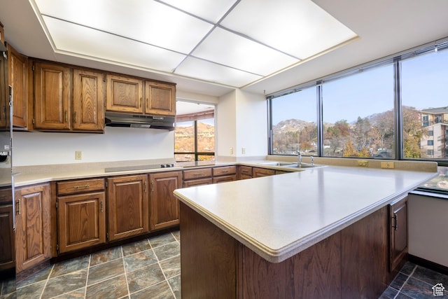 426 S 1000 E Unit 600, Salt Lake City, UT 84102 - kitchen with under cabinet range hood, a peninsula, light countertops, and brown cabinetry