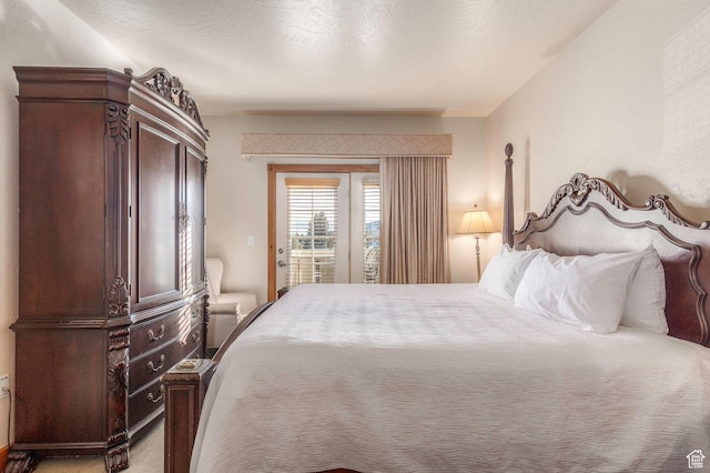 carpeted bedroom featuring access to exterior and a textured ceiling
