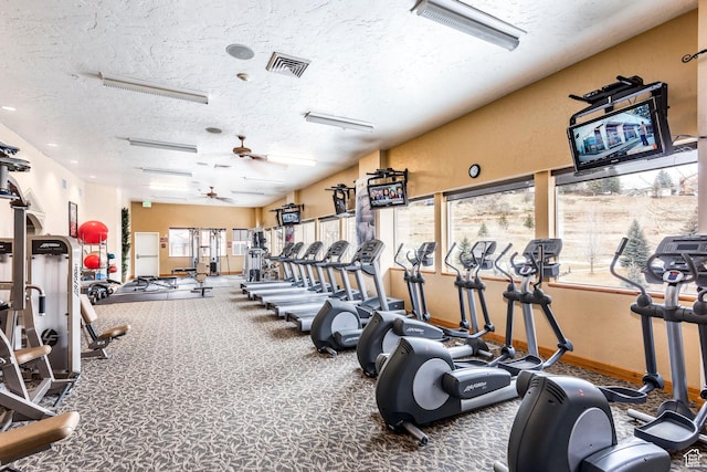 exercise room with ceiling fan, carpet floors, and a textured ceiling