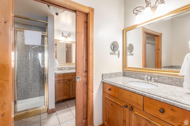 bathroom with tile patterned flooring, vanity, and an enclosed shower