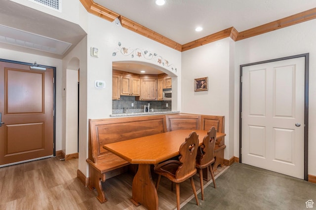 dining space featuring hardwood / wood-style flooring and crown molding