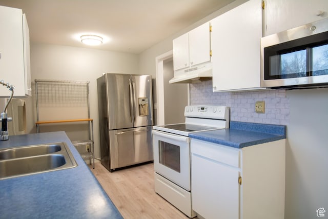 kitchen with decorative backsplash, light wood-type flooring, stainless steel appliances, sink, and white cabinetry