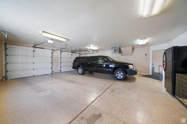 2594 W 1800 N, Farr West, UT 84404 - garage featuring black fridge and a garage door opener