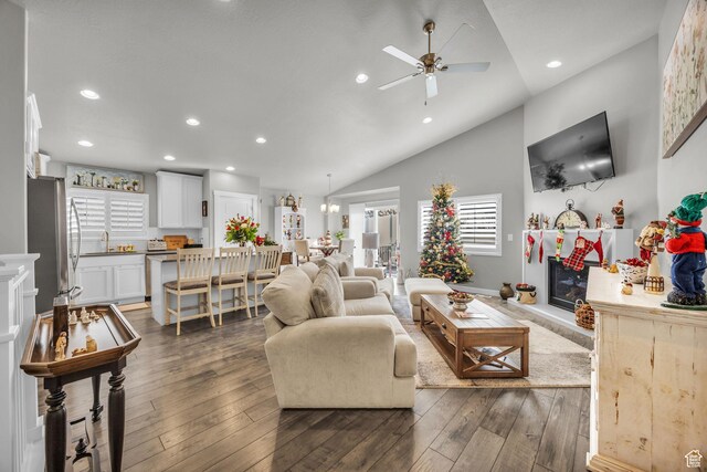 living room featuring dark hardwood / wood-style floors, high vaulted ceiling, ceiling fan, and sink