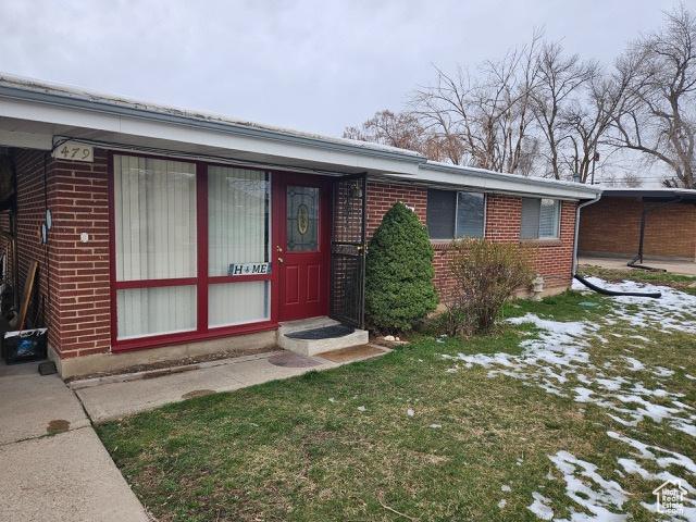 479 N Valeria Dr E, Layton, UT 84041 - doorway to property with a yard and brick siding