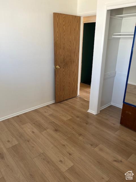 479 N Valeria Dr E, Layton, UT 84041 - unfurnished bedroom with a closet, baseboards, and wood finished floors
