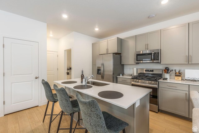 2278 N Canal View Ln, Heber City, UT 84032 - kitchen with gray cabinetry, stainless steel appliances, sink, a center island with sink, and light hardwood / wood-style flooring