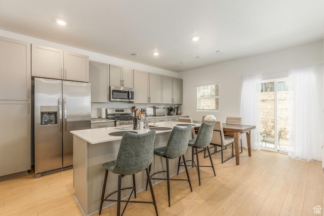 2278 N Canal View Ln, Heber City, UT 84032 - kitchen with gray cabinetry, an island with sink, stainless steel appliances, and light wood-type flooring