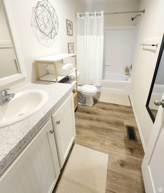 573 S Aspen Dr, Garden City, UT 84028 - full bathroom with hardwood / wood-style flooring, vanity, shower / bath combination with curtain, and toilet