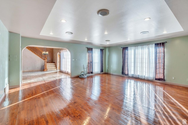 1402 Shepherd Dr, Wellington, UT 84542 - unfurnished living room with a raised ceiling, a wealth of natural light, and hardwood / wood-style flooring