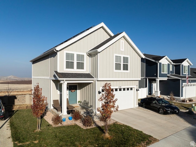 view of front of home featuring a mountain view, a front lawn, and a garage