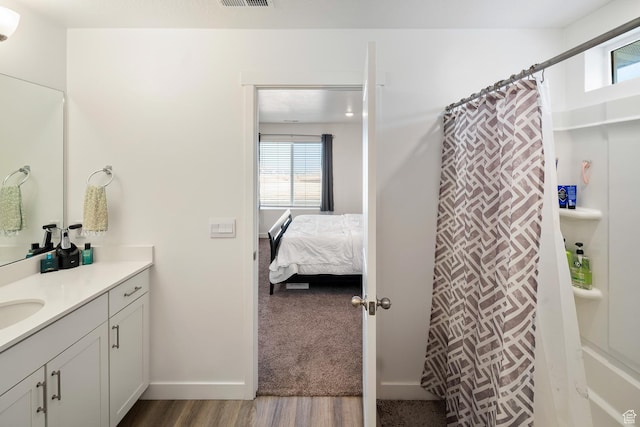 bathroom featuring hardwood / wood-style floors, vanity, and curtained shower