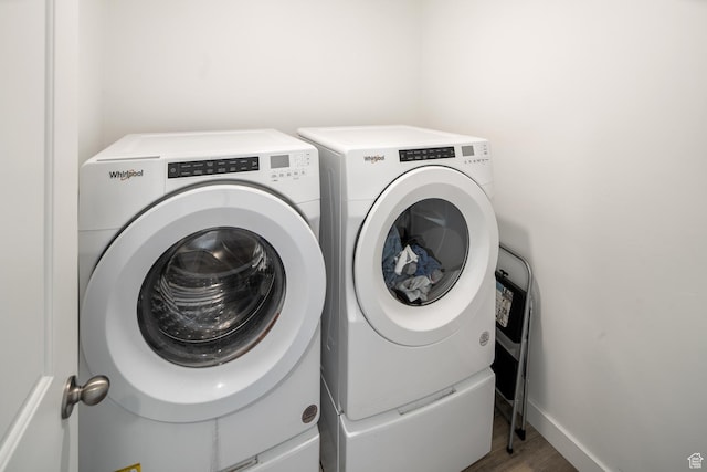 laundry room featuring independent washer and dryer and hardwood / wood-style floors