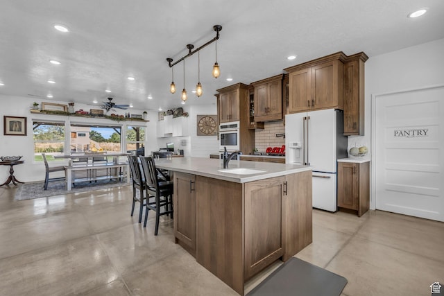 30 W 400 N, Fillmore, UT 84631 - kitchen with ceiling fan, a kitchen island with sink, sink, white fridge with ice dispenser, and hanging light fixtures