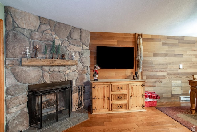 407 S Vasels Rd Unit 65, Brian Head, UT 84719 - living room with a textured ceiling, wood walls, light wood-type flooring, and a fireplace