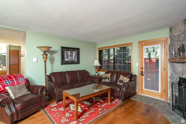 407 S Vasels Rd Unit 65, Brian Head, UT 84719 - living room featuring a textured ceiling, a stone fireplace, and dark wood-type flooring