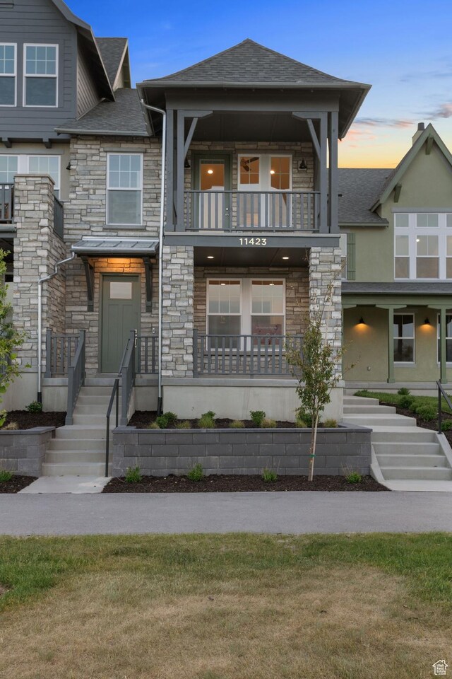 11423 S Watercourse Rd, South Jordan, UT 84009 - view of front of property featuring a balcony, stone siding, a shingled roof, and stucco siding