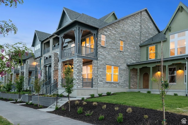 11423 S Watercourse Rd, South Jordan, UT 84009 - view of front of house with stone siding, a balcony, a front lawn, and covered porch