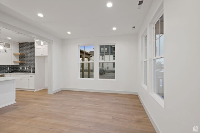 11423 S Watercourse Rd, South Jordan, UT 84009 - unfurnished dining area with recessed lighting, light wood finished floors, baseboards, and a sink