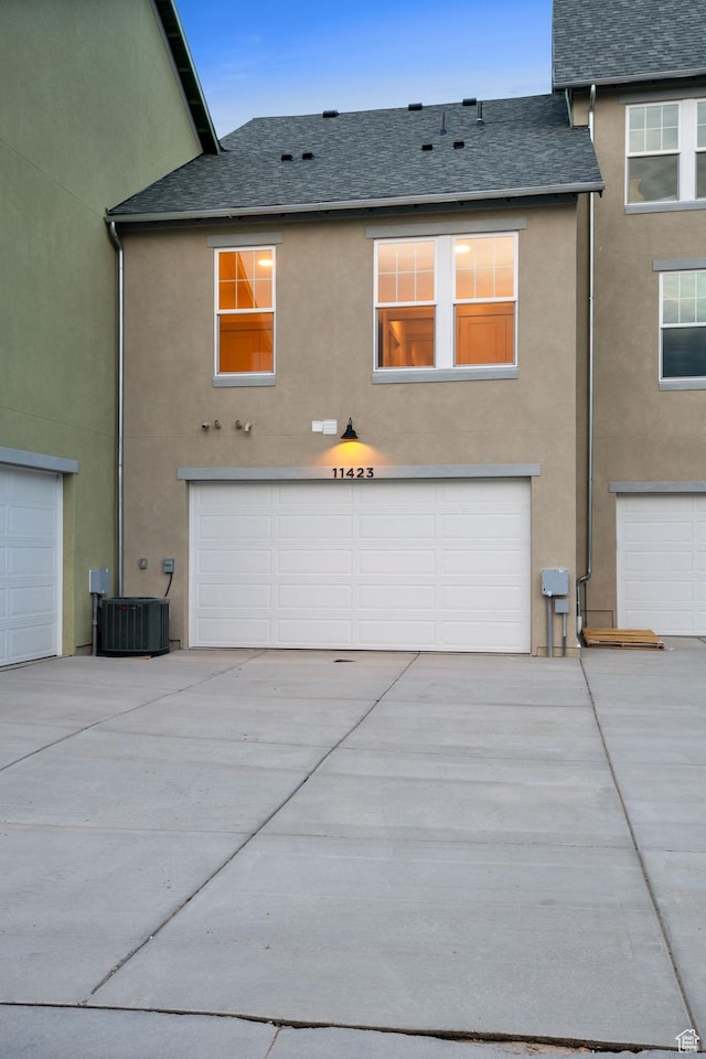 11423 S Watercourse Rd, South Jordan, UT 84009 - back of house with stucco siding, roof with shingles, a garage, and driveway