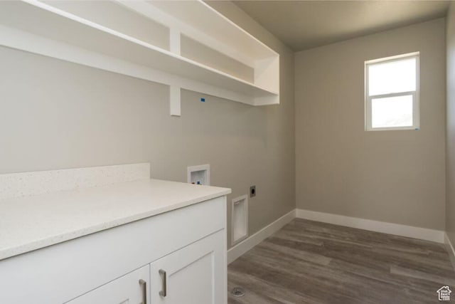 laundry area featuring electric dryer hookup, dark hardwood / wood-style flooring, cabinets, and washer hookup