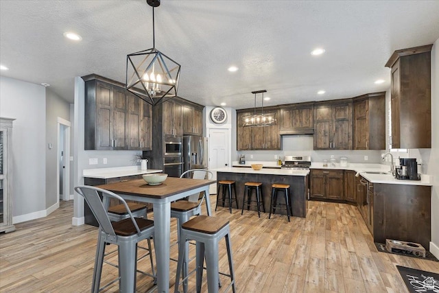 3851 N 425 E, North Ogden, UT 84414 - kitchen featuring a kitchen island, dark brown cabinetry, light wood-type flooring, and hanging light fixtures