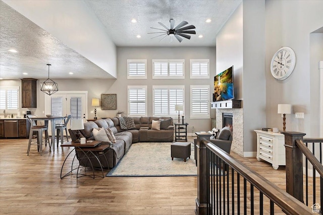3851 N 425 E, North Ogden, UT 84414 - living room with ceiling fan, light hardwood / wood-style floors, a towering ceiling, and a textured ceiling